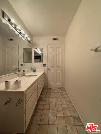 a spacious bathroom with a double vanity sink and mirror
