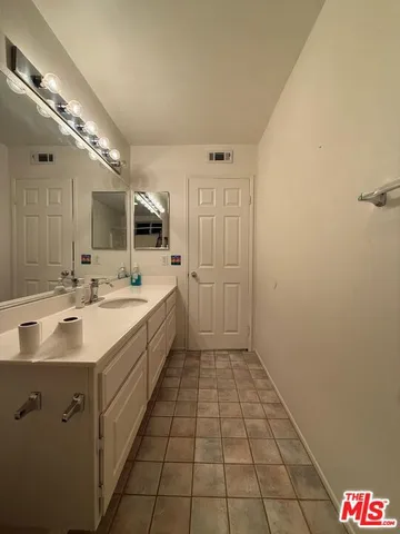 a spacious bathroom with a double vanity sink and mirror