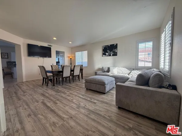 a living room with furniture flat screen tv and window