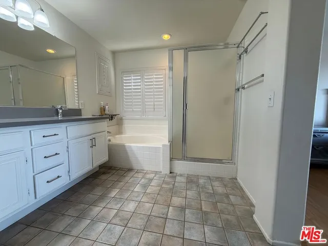 a bathroom with a mirror a bathtub and a shower