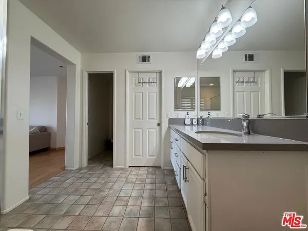 a spacious bathroom with a double vanity sink a mirror and a shower