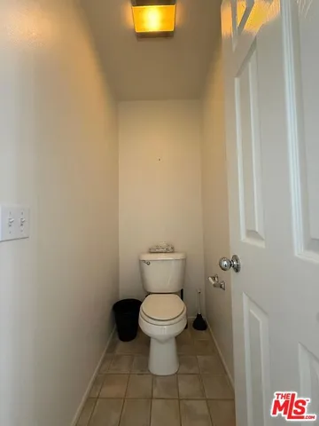 a white toilet sitting next to a white wall