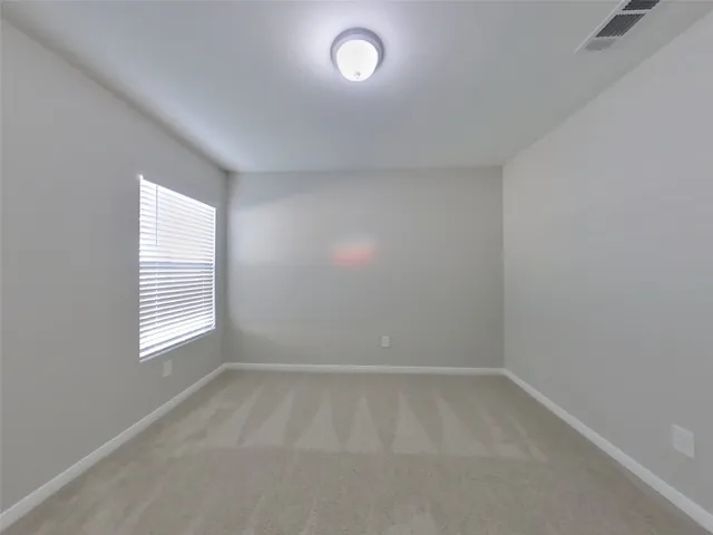 an empty room with a window and wooden floor