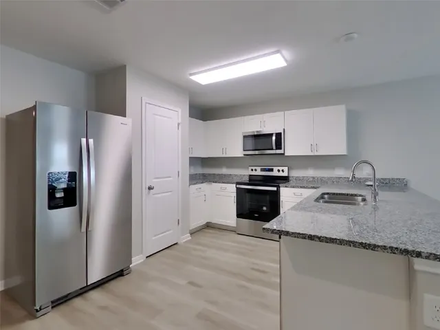 a kitchen with granite countertop stainless steel appliances and a refrigerator