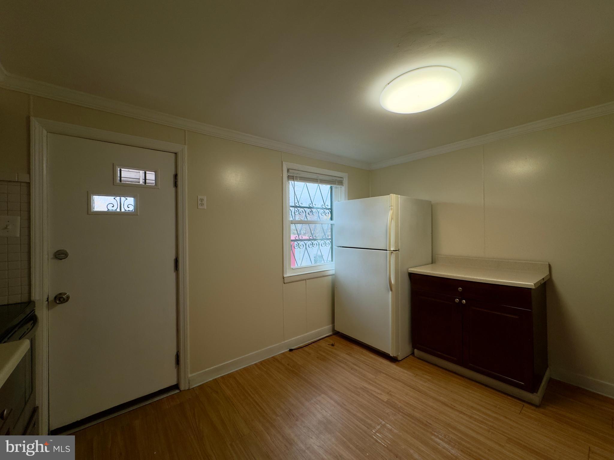 116 Carver Road Dundalk, MD 21222 - Photo 8 of 19 a view of an empty room with wooden floor and cabinet
