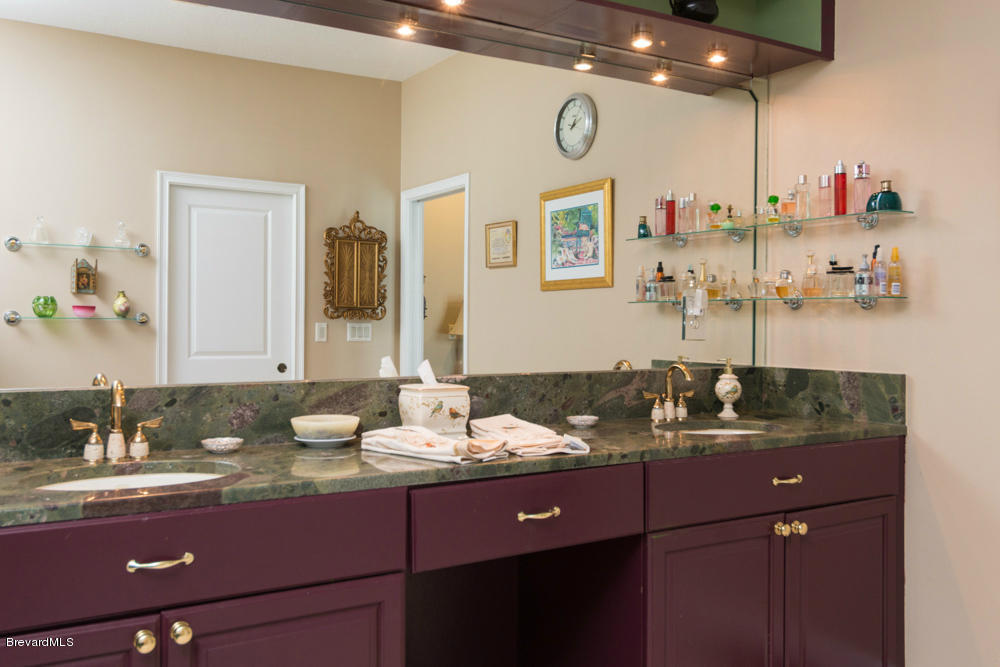 4175 Turtle Mound Road Melbourne, FL 32934 - Photo 11 of 26 a bathroom with a granite countertop sink a large mirror and a window