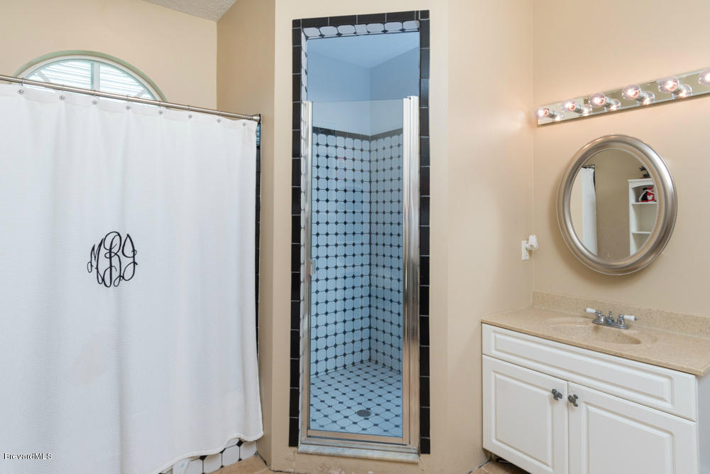 4175 Turtle Mound Road Melbourne, FL 32934 - Photo 14 of 26 a bathroom with a sink and a mirror