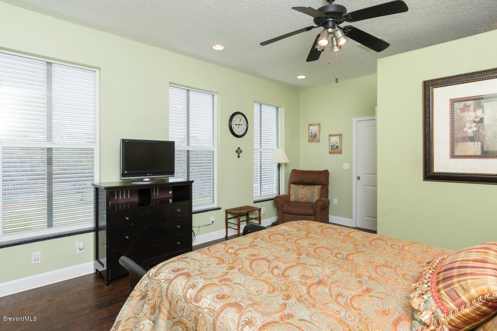 4175 Turtle Mound Road Melbourne, FL 32934 - Photo 15 of 26 a bedroom with a bed and a flat tv screen on dresser