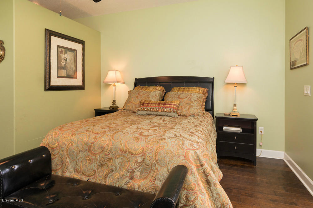 4175 Turtle Mound Road Melbourne, FL 32934 - Photo 16 of 26 a bedroom with a bed and a lamp on table