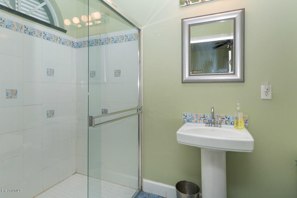 4175 Turtle Mound Road Melbourne, FL 32934 - Photo 17 of 26 a bathroom with a sink and a mirror