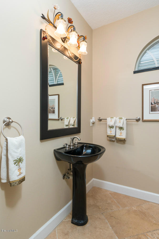 4175 Turtle Mound Road Melbourne, FL 32934 - Photo 18 of 26 a bathroom with a sink and a mirror