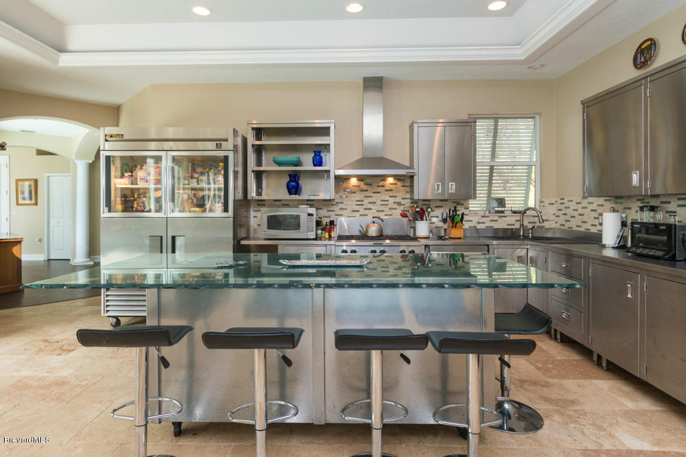 4175 Turtle Mound Road Melbourne, FL 32934 - Photo 6 of 26 a kitchen with center island table and chairs