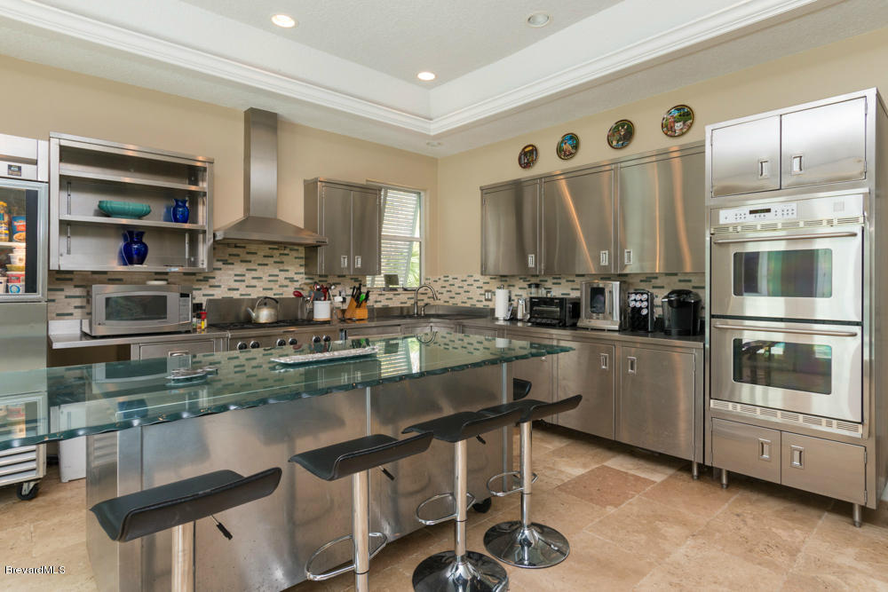 4175 Turtle Mound Road Melbourne, FL 32934 - Photo 7 of 26 a kitchen with stainless steel appliances granite countertop a stove a sink and a refrigerator