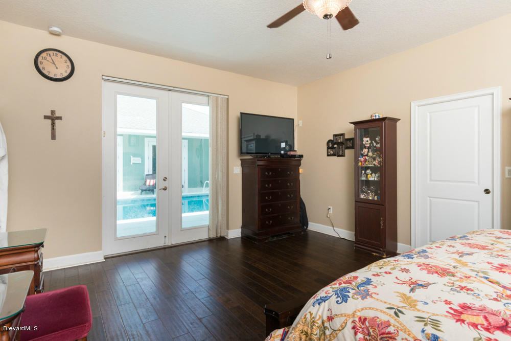 4175 Turtle Mound Road Melbourne, FL 32934 - Photo 9 of 26 a bedroom with a bed and wooden floor
