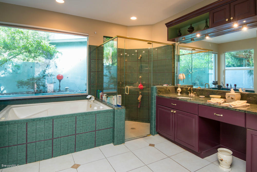 4175 Turtle Mound Road Melbourne, FL 32934 - Photo 10 of 26 a bathroom with a tub sink and mirror