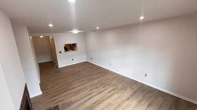 an empty room with wooden floor and entrance