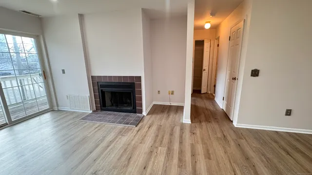a view of a livingroom with wooden floor and a fireplace