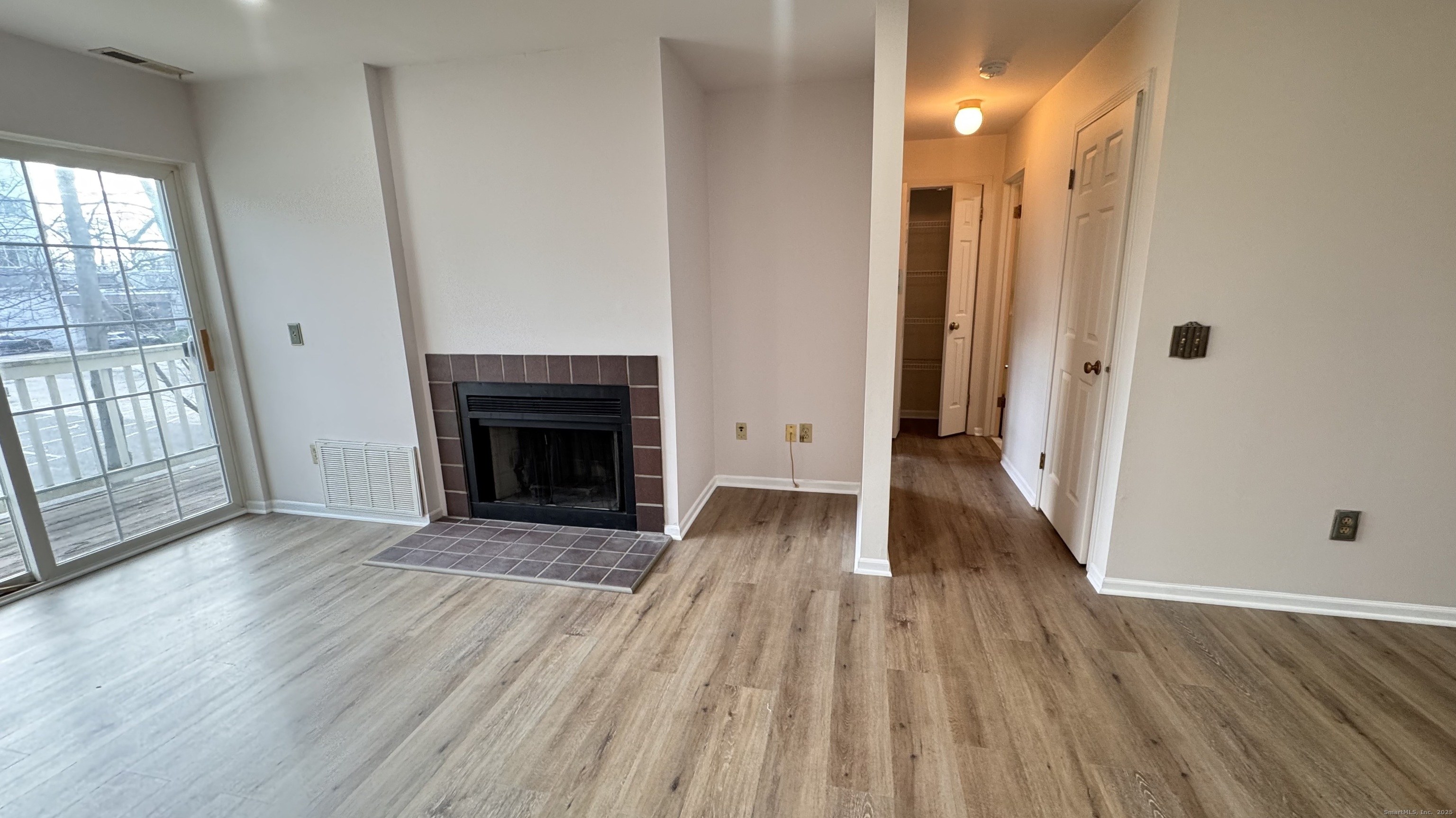 25 Janet Circle, Unit F Bridgeport, CT 06606 - Photo 6 of 22 a view of a livingroom with wooden floor and a fireplace