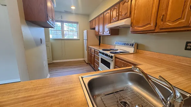 a kitchen with stainless steel appliances granite countertop a stove a sink and a refrigerator