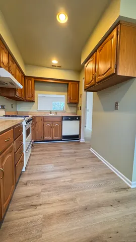 a large kitchen with stainless steel appliances granite countertop a stove and a sink
