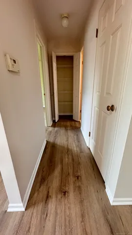 a view of a hallway with wooden floor and staircase