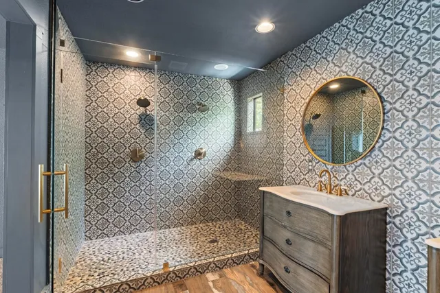 a bathroom with a sink mirror and shower