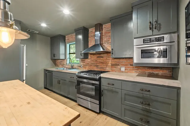 a kitchen with stainless steel appliances kitchen island granite countertop a sink and cabinets