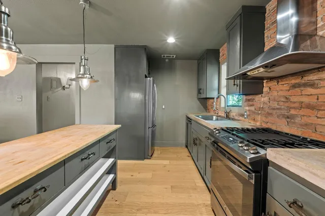 a kitchen with a stove and a wooden floor