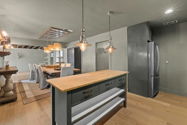 a kitchen with kitchen island a counter top space a sink stainless steel appliances and cabinets