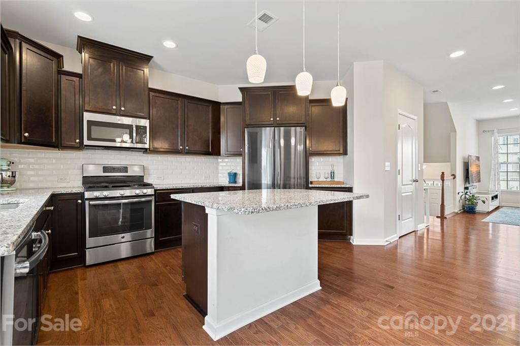 212 Butterfly Place, Unit 188 Tega Cay, SC 29708 - Photo 22 of 33 a kitchen with stainless steel appliances kitchen island granite countertop a stove a sink and a refrigerator