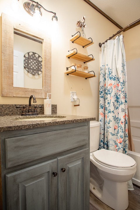 148 Thomas Road Livingston, TN 38570 - Photo 22 of 38 a bathroom with a sink a toilet and a shower curtain