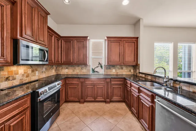 a kitchen with stainless steel appliances granite countertop a sink and a granite counter tops