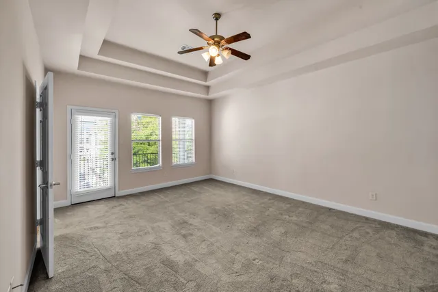 a view of an empty room with chandelier fan