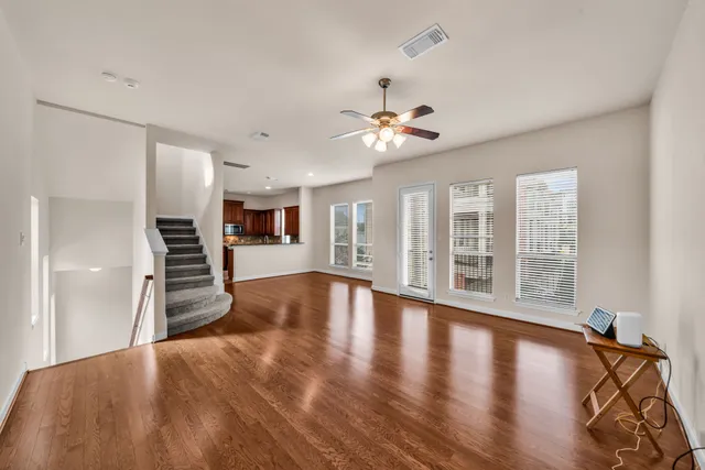 a view of empty room with wooden floor and window
