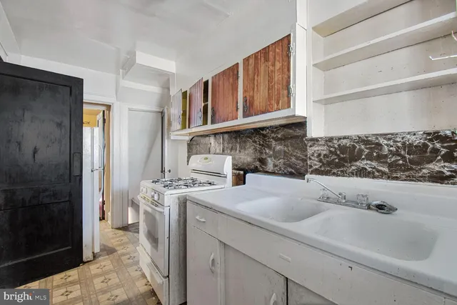 a kitchen with a stove sink and cabinets