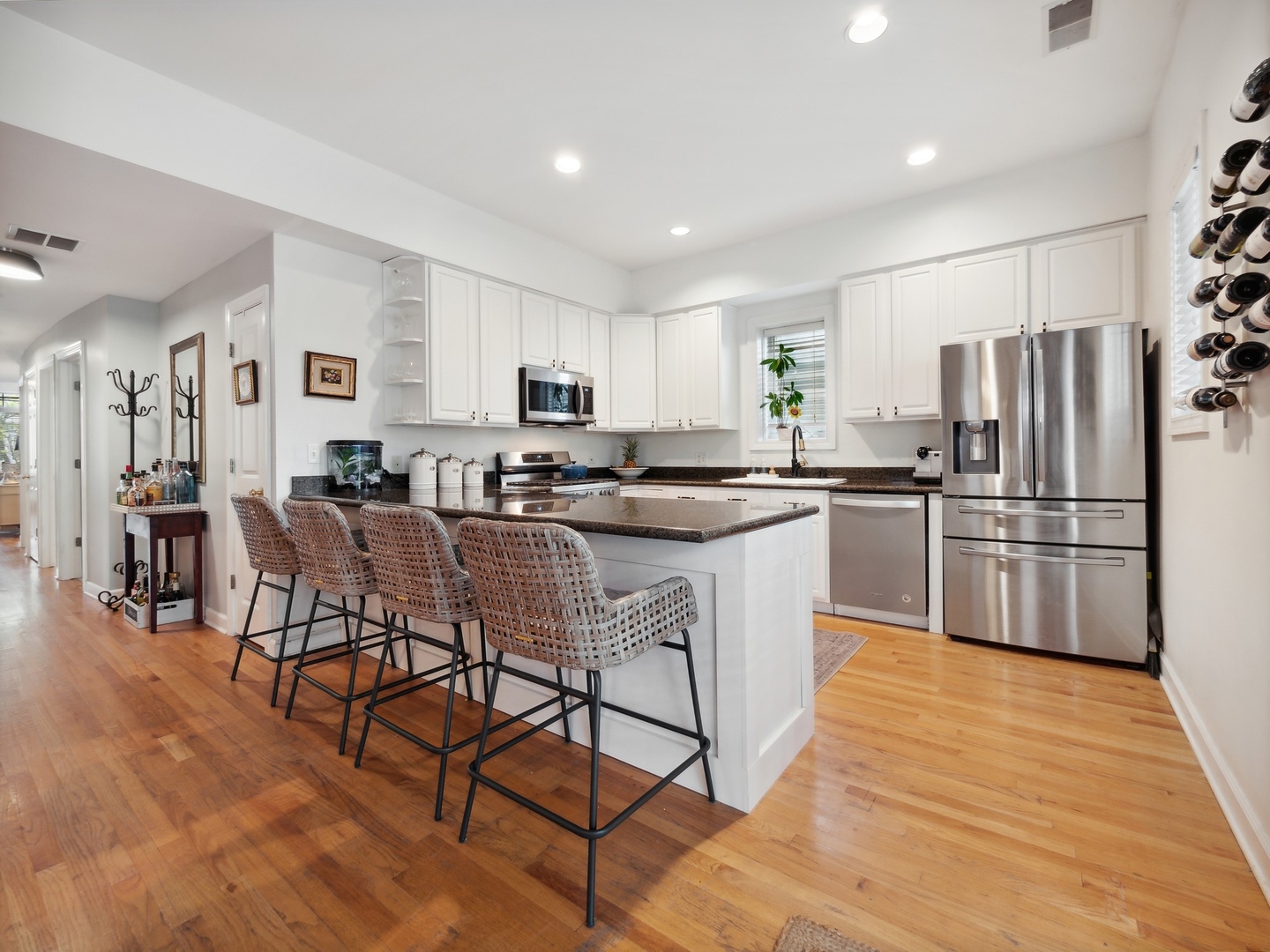 1827 West Addison Street, Unit 2 Chicago, IL 60613 - Photo 8 of 18 a kitchen with stainless steel appliances a refrigerator a stove a sink dishwasher and a dining table with wooden floor
