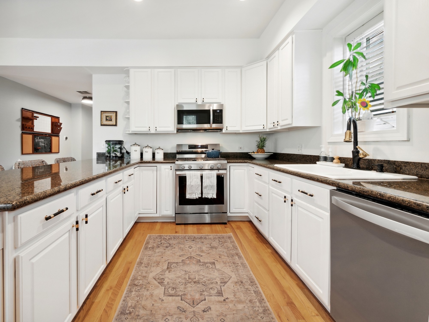 1827 West Addison Street, Unit 2 Chicago, IL 60613 - Photo 9 of 18 a large white kitchen with stainless steel appliances granite countertop lots of counter space sink and cabinets