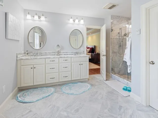 a bathroom with a granite countertop sink a mirror and a shower