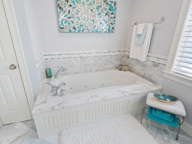 a white bath tub sitting next to a white cabinet