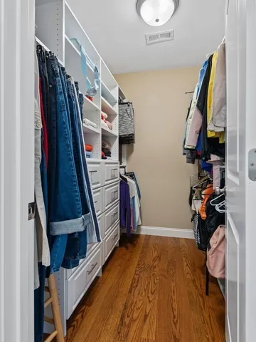 a view of walk in closet with clothes and shoes