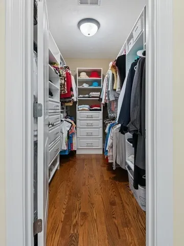 a view of walk in closet with clothes and shoes