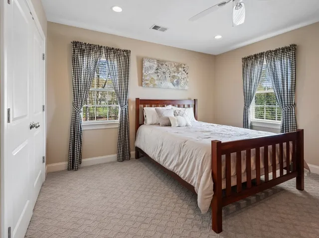 a bed sitting in a spacious bedroom next to a window