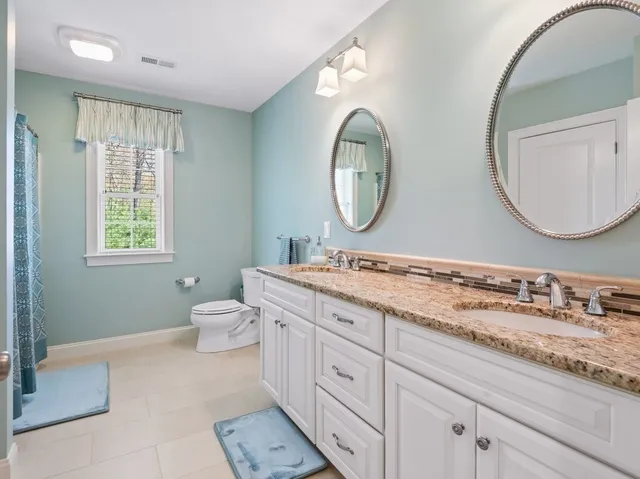 a bathroom with a granite countertop toilet a sink and a mirror