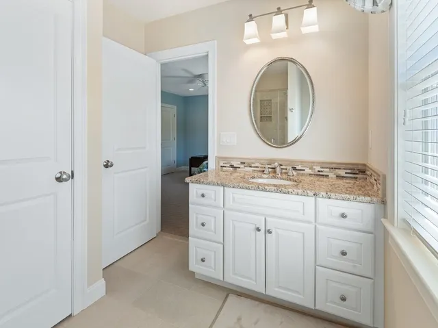 a bathroom with a granite countertop double vanity sink and a mirror