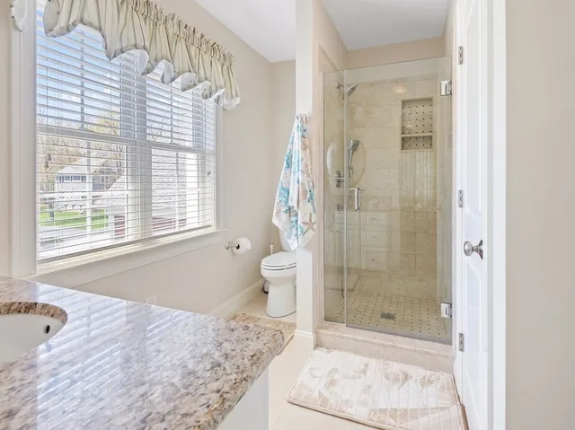 a bathroom with a bathtub shower and toilet