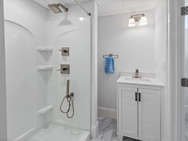 a bathroom with a shower sink and mirror