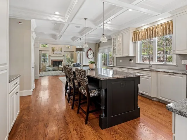 a kitchen with stainless steel appliances granite countertop wooden floors and wooden cabinets