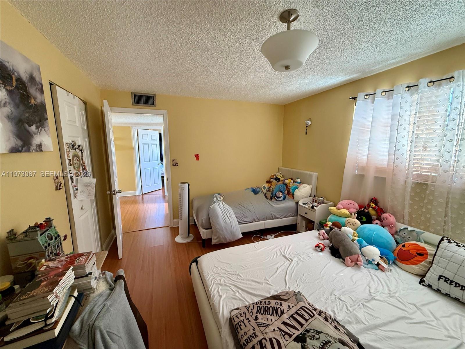 1236 Alton Road, Unit 401 Miami Beach, FL 33139 - Photo 13 of 14 a bedroom with a bed and a chandelier