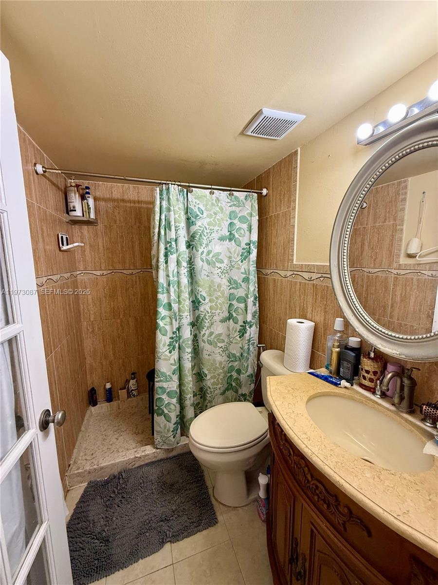 1236 Alton Road, Unit 401 Miami Beach, FL 33139 - Photo 14 of 14 a bath room with a toilet a sink and a mirror