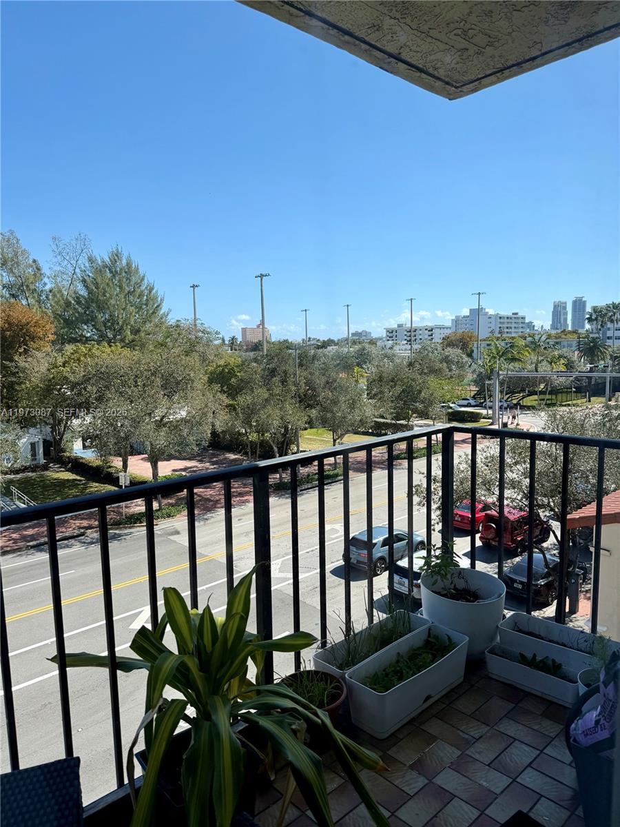 1236 Alton Road, Unit 401 Miami Beach, FL 33139 - Photo 5 of 14 a view of a balcony with chairs and wooden fence
